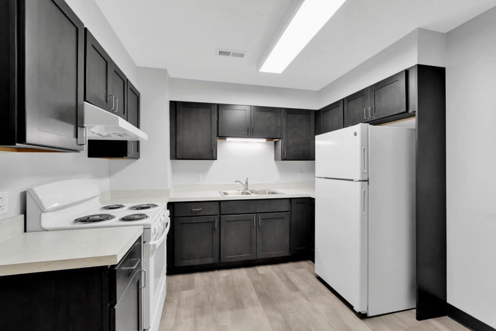 Renovated resident kitchen at Capitol Station senior living community in Indianapolis featuring updated cabinetry, finishes, and lighting.